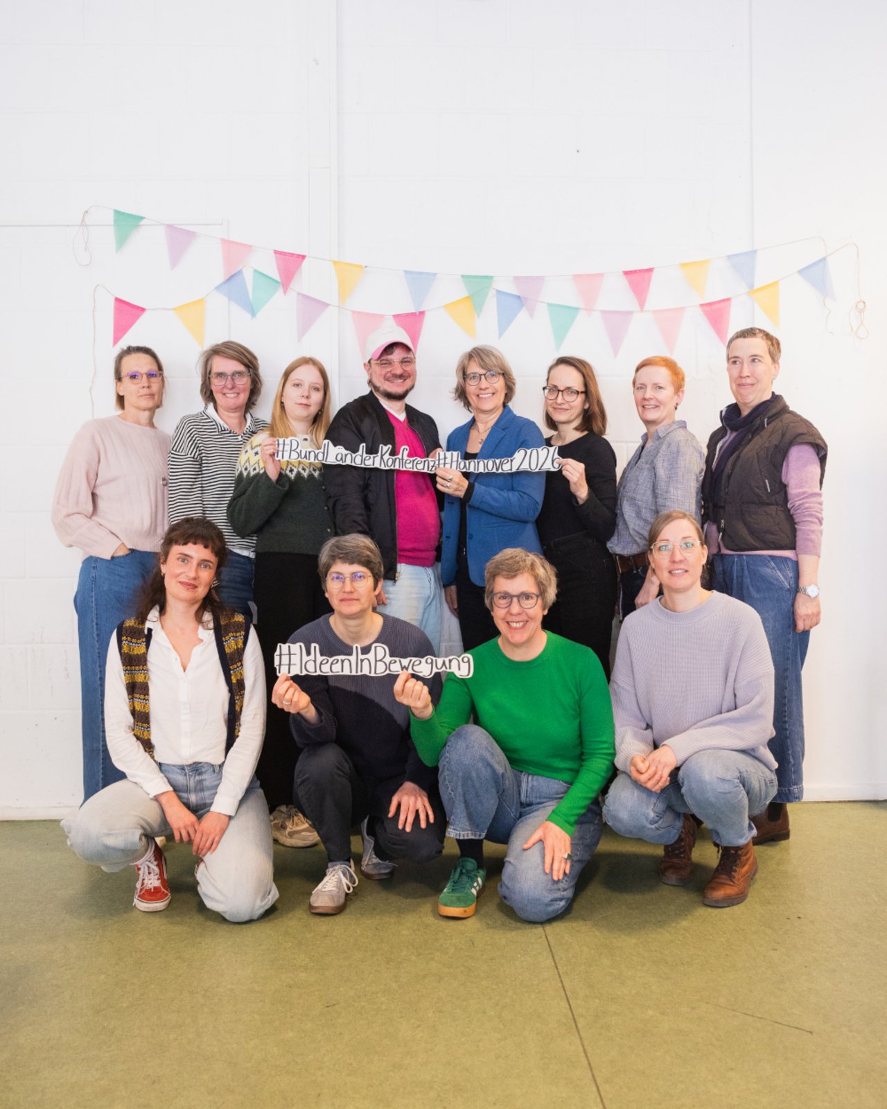 Zum Abschluss der zweitägigen Konferenz kommen alle LKJ- und BKJ-Vertreter*innen zu einem Gruppenbild  zusammen. Einige halten die ausgedruckten Slogans #BundLänderKonfernz, #Hannover2026 und #IdeenInBewegung in den Händen.